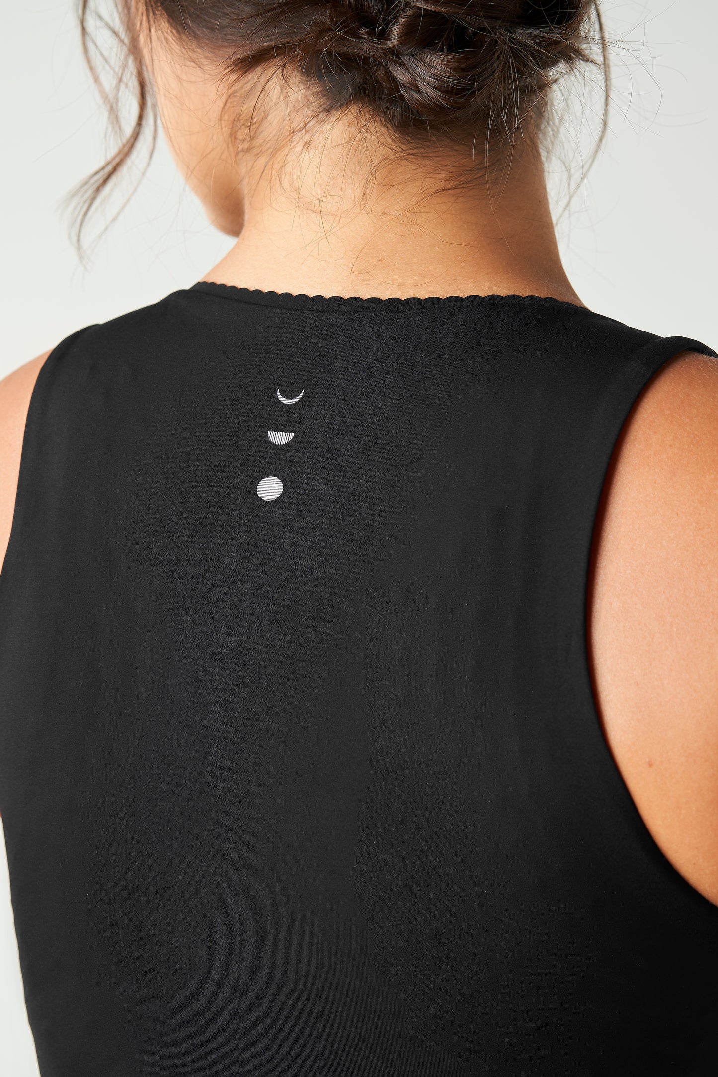 Débardeur Adorn en noir, avec un élégant bord festonné, en tissu de compression certifié OEKO-tex, doté de notre technologie MicroPerle® pour le drainage lymphatique, une meilleure circulation et la réduction de la fatigue.
