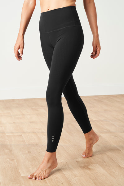 Legging Adorn en noir, avec un élégant bord festonné, en tissu de compression certifié OEKO-tex, notre technologie MicroPerle® pour le drainage lymphatique, une meilleure circulation, la réduction de la fatigue et une peau plus lisse.