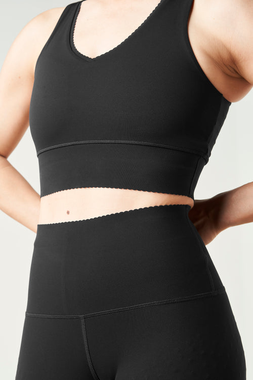 Charger l&#39;image 1 dans la galerie. Brassière Adorn en noir, avec un élégant bord festonné, en tissu de compression certifié OEKO-tex, dotée de notre technologie MicroPerle® pour le drainage lymphatique, une meilleure circulation et la réduction de la fatigue.