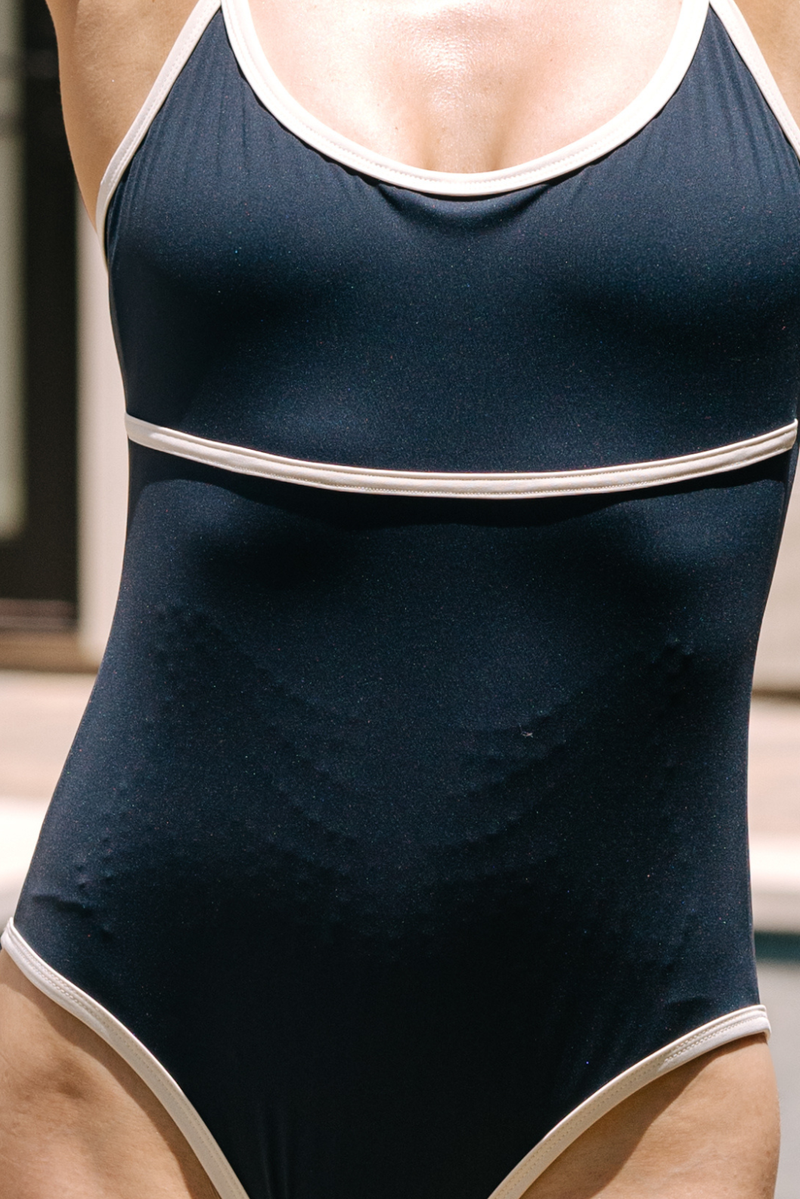 Gros plan du body Monte Carlo coloris Navy mettant en évidence la technologie MicroPerle® intégrée. Le relief texturé des MicroPerle® est visible sur l’abdomen, conçu pour accompagner le mouvement et offrir une expérience de massage inspirée du drainage lymphatique au quotidien.