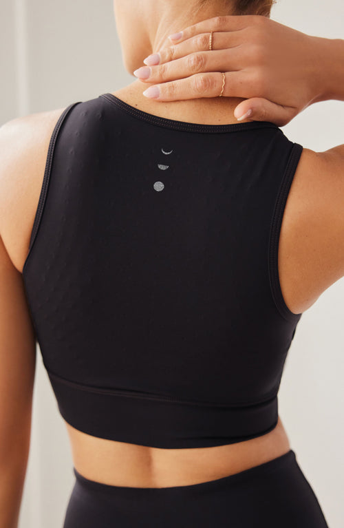 Charger l&#39;image 1 dans la galerie. Mannequin portant la brassière Divine en couleur noire avec billes MicroPerle dans le dos, tissu de compression certifié OEKO-TEX pour drainage lymphatique, une meilleure circulation et réduction de douleurs musculaires