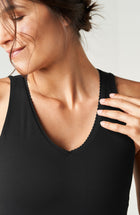 Débardeur Adorn en noir, avec un élégant bord festonné, en tissu de compression certifié OEKO-tex, doté de notre technologie MicroPerle® pour le drainage lymphatique, une meilleure circulation et la réduction de la fatigue.
