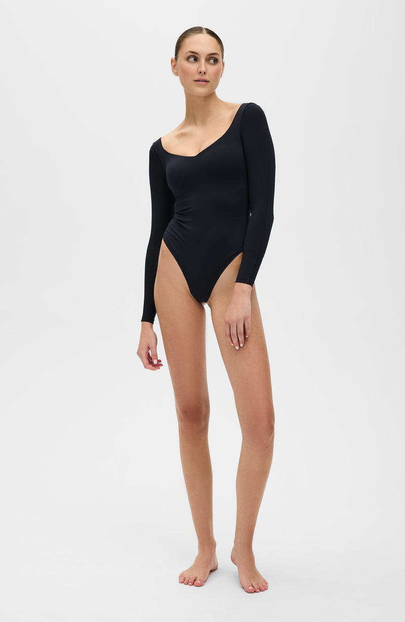 Body de Compression Manches Longues Iconic - String en noir. Conçu pour améliorer la circulation, offrir une compression douce et sculpter la silhouette en toute simplicité grâce à un tissu de compression certifié OEKO-TEX.