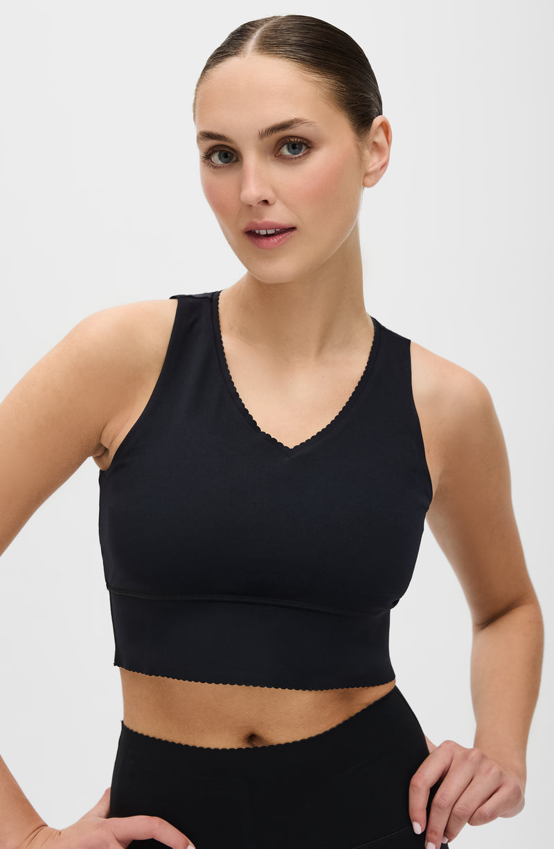 Brassière Adorn en noir, avec un élégant bord festonné, en tissu de compression certifié OEKO-tex, dotée de notre technologie MicroPerle® pour le drainage lymphatique, une meilleure circulation et la réduction de la fatigue.
