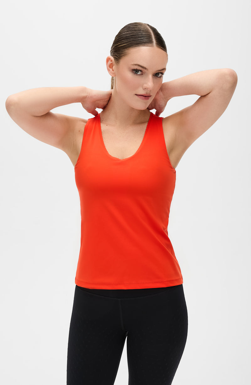 Débardeur Adorn en coloris coquelicot, avec un élégant bord festonné, en tissu de compression certifié OEKO-tex, doté de notre technologie MicroPerle® pour le drainage lymphatique, une meilleure circulation et la réduction de la fatigue.