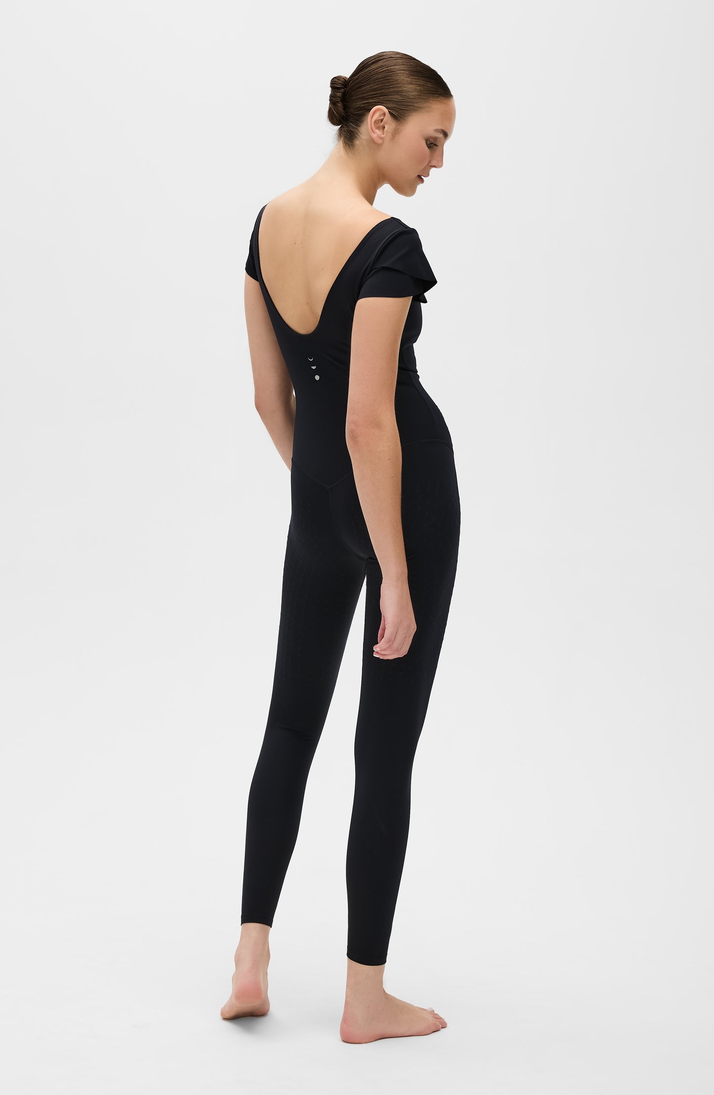 La combinaison Le Cha-Cha, de couleur noire, présente un dos échancré sophistiqué, des manches délicates et une silhouette épurée. Fabriquée avec un tissu de compression certifié OEKO-tex, notre technologie MicroPerle® favorise le drainage lymphatique, améliore la circulation, réduit la fatigue et booste la vitalité.