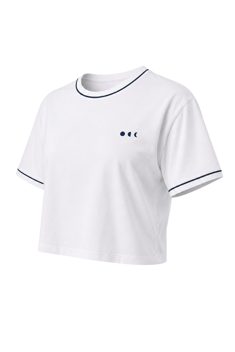 T-shirt Crop blanc de la collection Monte Carlo avec finitions contrastées bleu marine. Inspiré de l’univers balnéaire haut de gamme, ce modèle allie confort au quotidien, élégance sportive et polyvalence, aussi bien pour les moments de détente que pour la vie active au bord de la piscine.