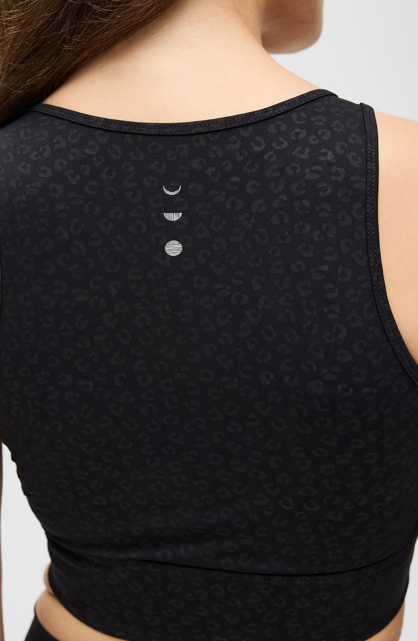 Mannequin portant la brassière Fierce à imprimé léopard de la collection Fierce d’Elastique, confectionné dans un tissu de compression certifié OEKO-TEX®, doté de la technologie MicroPerle® pour stimuler la circulation, favoriser le drainage lymphatique et lisser la peau.