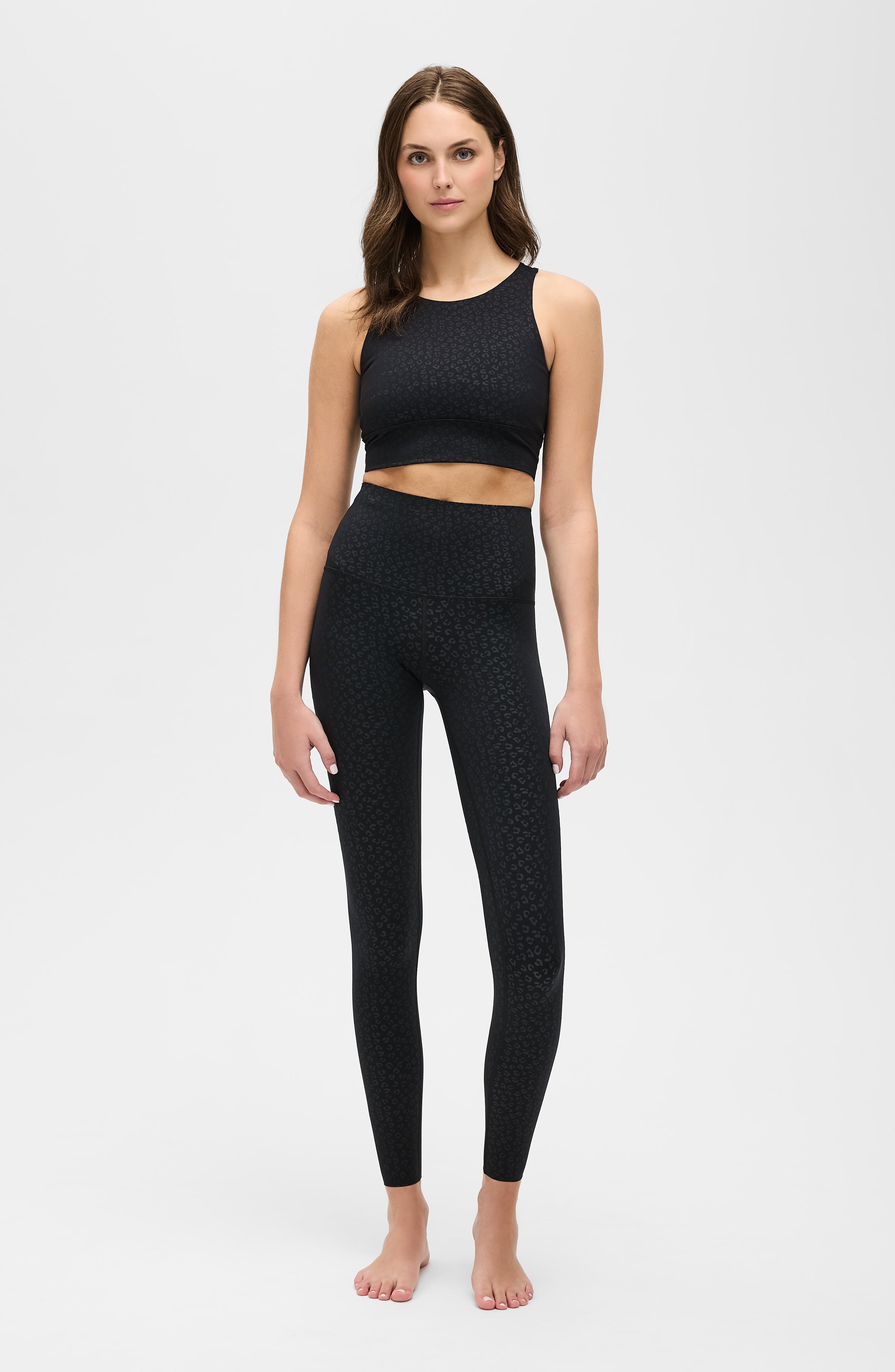 Modèle portant le legging Fierce en noir avec imprimé léopard, conçu avec un tissu compressif certifié OEKO-TEX et notre technologie MicroPerle® pour stimuler le drainage lymphatique, améliorer la circulation, réduire la fatigue et lisser la peau. Legging de compression