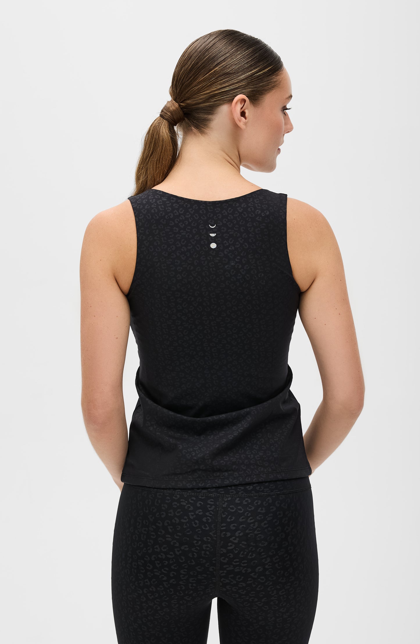 Modèle portant le legging Fierce en noir avec imprimé léopard, conçu avec un tissu compressif certifié OEKO-TEX et notre technologie MicroPerle® pour stimuler le drainage lymphatique, améliorer la circulation, réduire la fatigue et lisser la peau. Legging de compression