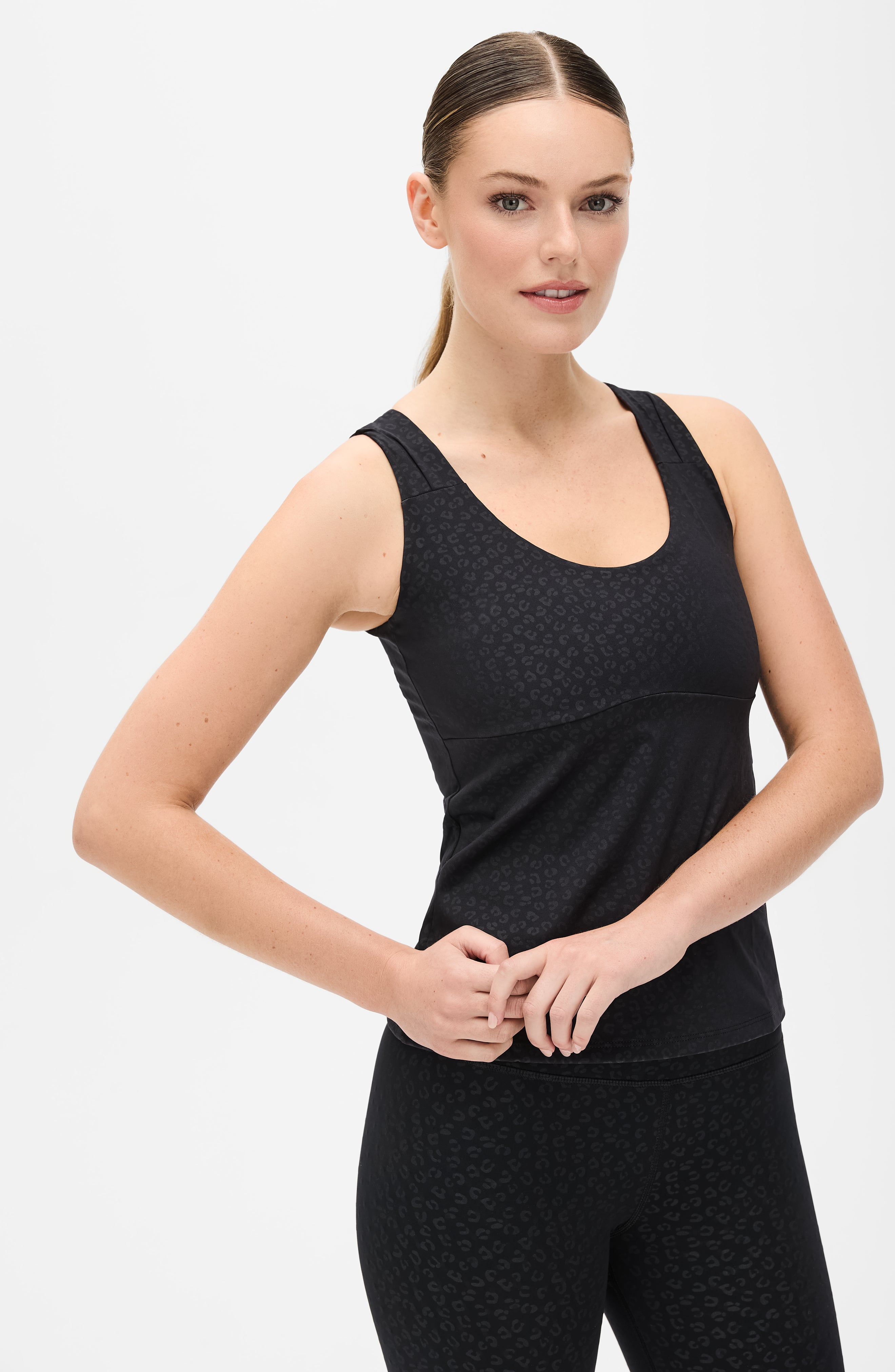 Modèle portant le legging Fierce en noir avec imprimé léopard, conçu avec un tissu compressif certifié OEKO-TEX et notre technologie MicroPerle® pour stimuler le drainage lymphatique, améliorer la circulation, réduire la fatigue et lisser la peau. Legging de compression