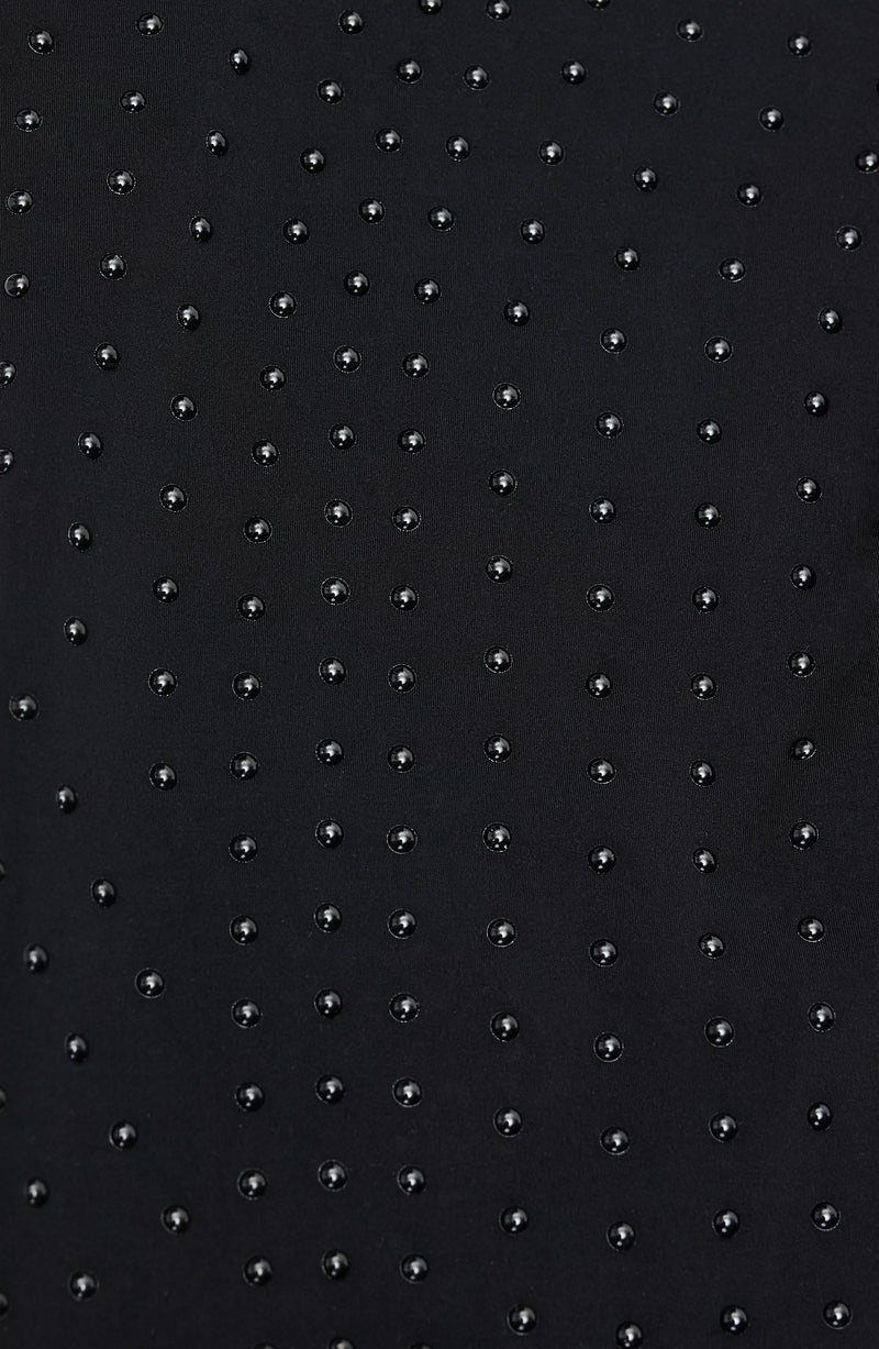 Focus sur les MicroPerle® sur du tissu noir permettant l'amélioration de la circulation, les jambes plus légères