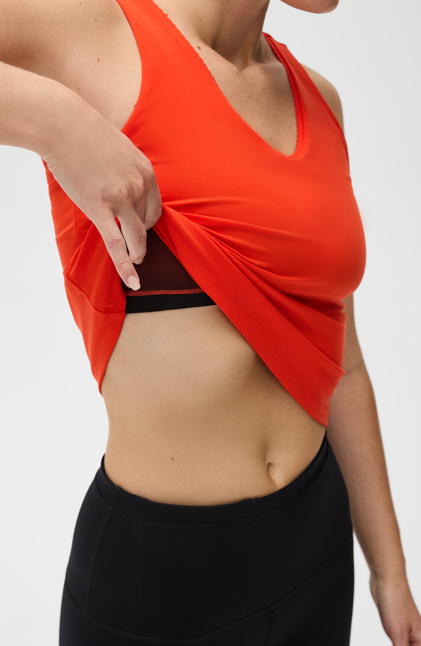 Débardeur Adorn en coloris coquelicot, avec un élégant bord festonné, en tissu de compression certifié OEKO-tex, doté de notre technologie MicroPerle® pour le drainage lymphatique, une meilleure circulation et la réduction de la fatigue.