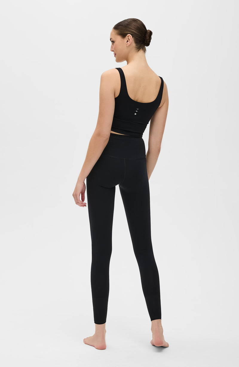 Mannequin portant le legging et brassière Lisse en couleur noire, confectionnés dans un tissu de compression certifié OEKO-TEX®, conçu pour sculpter la silhouette, stimuler la circulation et offrir une sensation lisse et seconde peau.