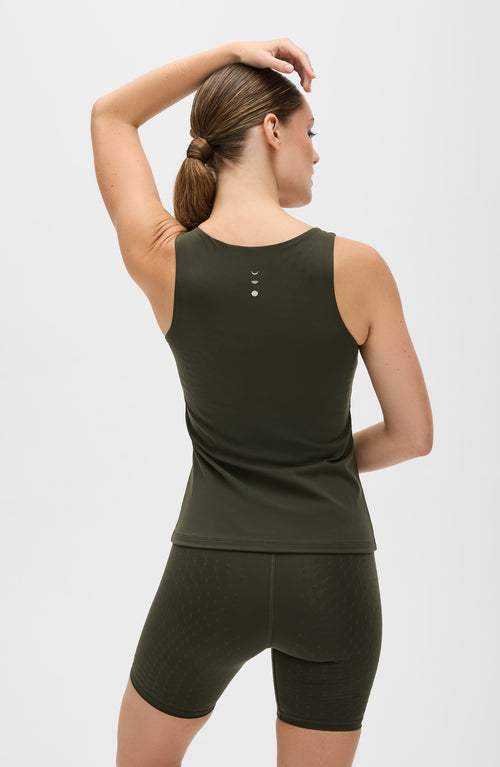 Charger l&#39;image 1 dans la galerie. Mannequin portant le débardeur L'Original en couleur verte olive avec billes MicroPerle dans le dos, tissu de compression certifié OEKO-TEX pour drainage lymphatique, une meilleure circulation et réduction de douleurs musculaires
